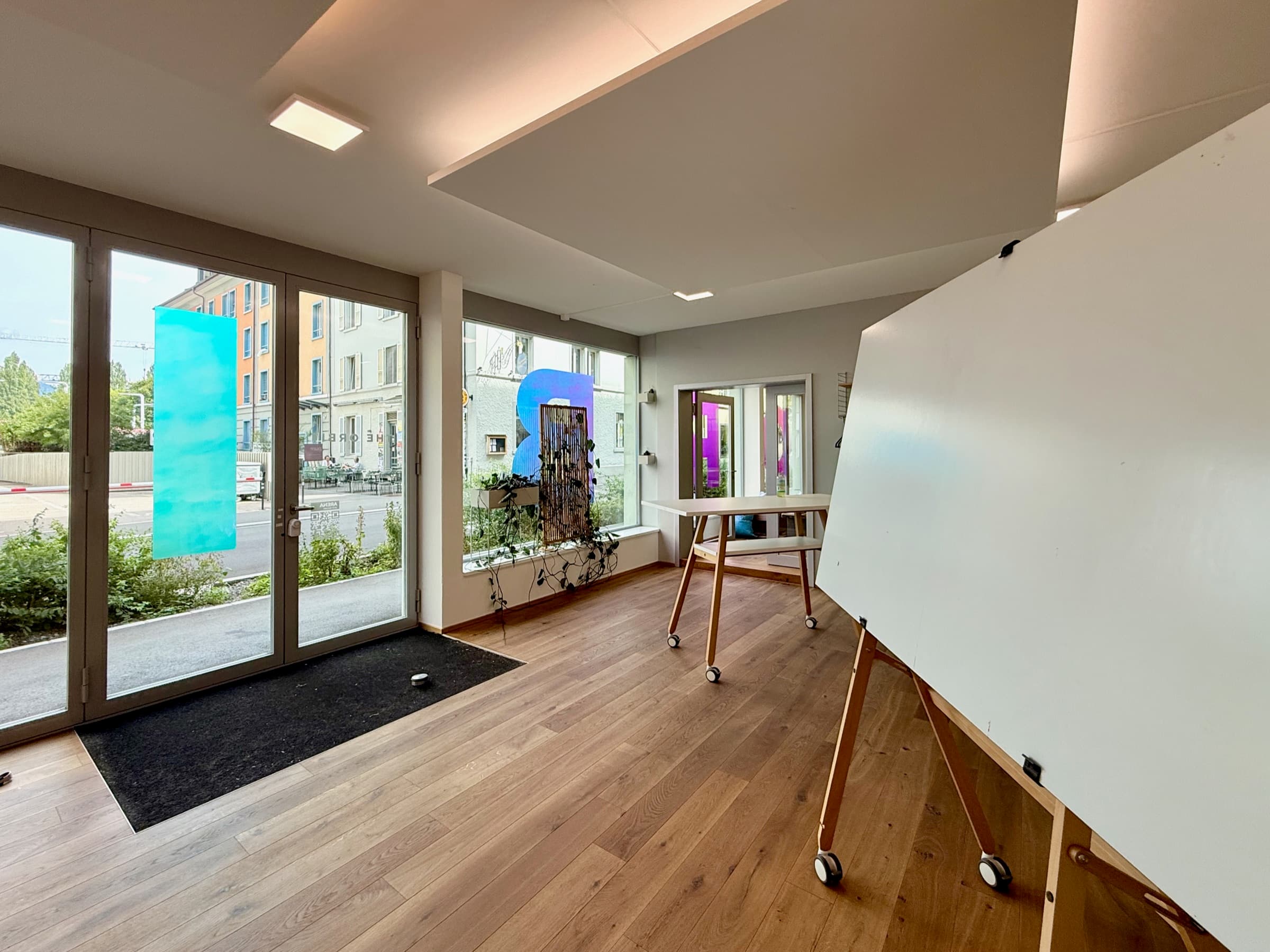 The Orbit an der Neustadtstrasse in Luzern: Eingang mit Glasfront, Stehtisch und Whiteboard auf Rollen